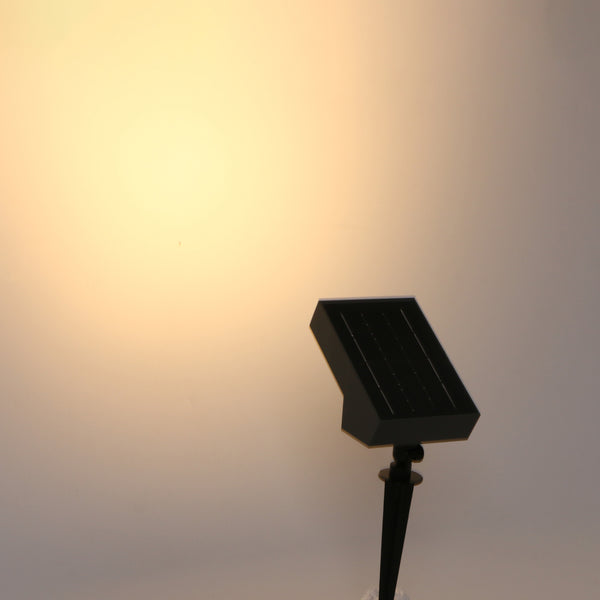 Adjustable solar flood light with motion sensor for outdoor security.