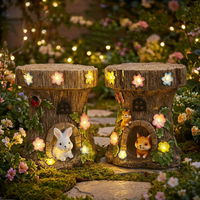 Two Solar Tree stump stools with glowing lights and squirrel figures in a garden setting.