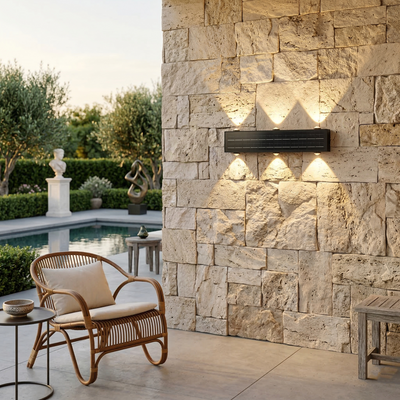 Outdoor setting with stone wall, wicker chair, and pool area.