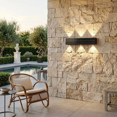 6-beam solar wall wash light mounted horizontally on limestone wall casting warm 3000K scalloped diamond pattern at dusk with rattan chair and pool in background