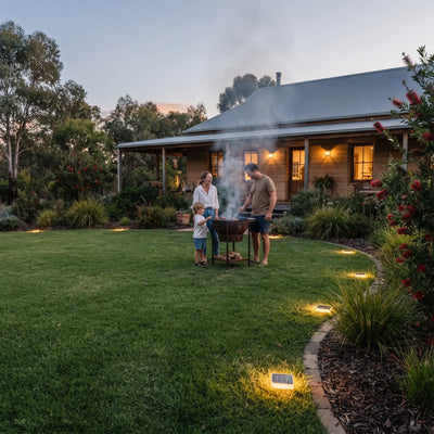 Lumterra PT0608 solar ground light illuminating a family BBQ in a lush backyard at dusk, creating a warm and inviting outdoor atmosphere.