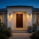HeritageGlow Solar Lantern mounted on white brick walls flanking front door at dusk, casting warm 2700K glow through clear glass panels — ideal for enhancing curb appeal and welcoming guests with Victorian-inspired elegance.