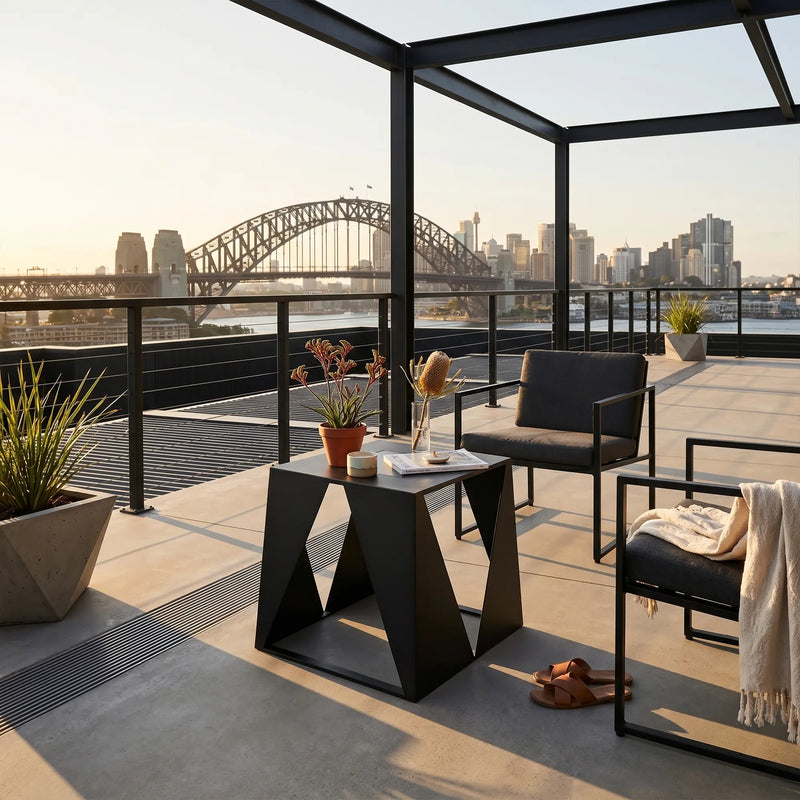 Modern outdoor furniture set on a rooftop with city skyline and bridge view.