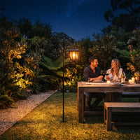 HeritageHook Solar Lantern on shepherd's hook beside garden dining table under starry sky, casting warm 2700K glow through six glass panels — ideal for romantic outdoor dinners and elegant lawn centrepieces.