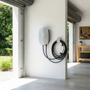 Electric vehicle charging station with coiled cable attached to a wall inside a modern home.