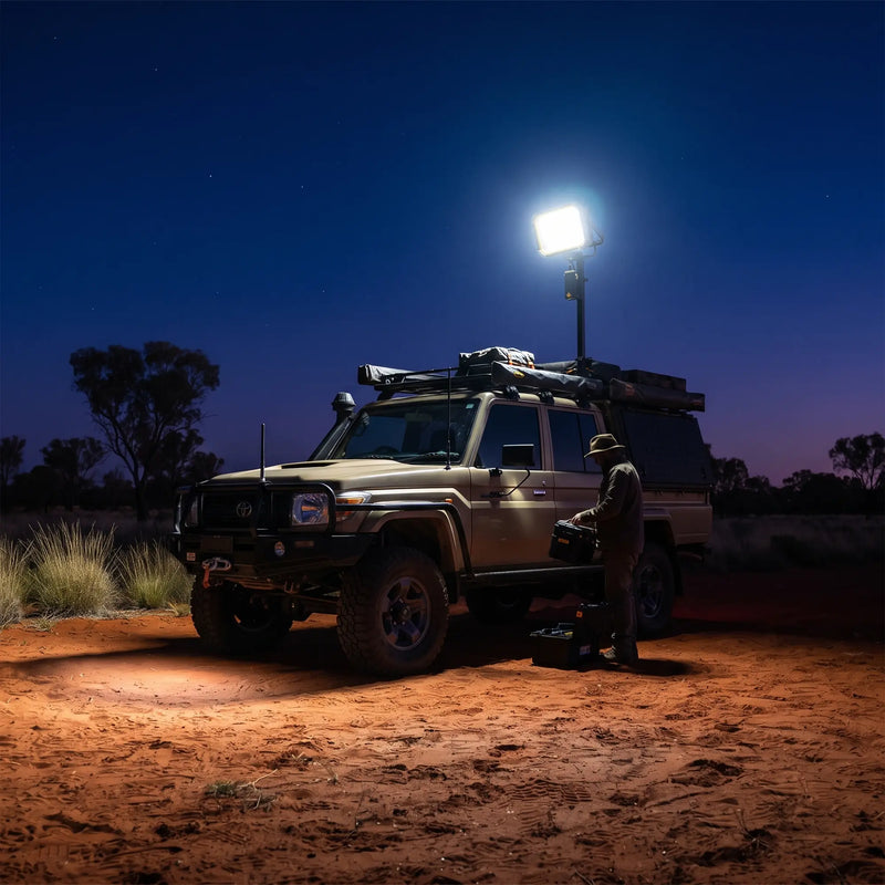 SolarFlex Pro mounted on pole illuminates 4WD at night in outback; man works beside vehicle under bright LED light.