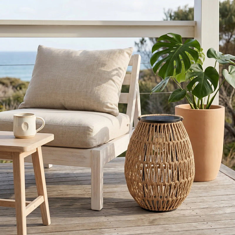 PT0906 solar handwoven garden path light on wooden deck beside armchair, PE rattan construction, solar panel top, coastal outdoor decor, UV-resistant garden lighting