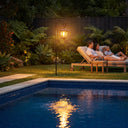 HeritageHook Solar Garden Light illuminating poolside lounge area at dusk, highlighting its IP44 weatherproof rating and suitability for luxury backyard retreats with tropical landscaping.