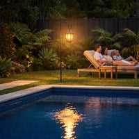 HeritageHook Solar Garden Light illuminating poolside lounge area at dusk, highlighting its IP44 weatherproof rating and suitability for luxury backyard retreats with tropical landscaping.