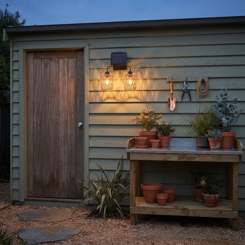 Solar-powered double lantern mounted beside garden shed door — illuminates potting bench with overlapping shadow art, showcasing practical use in utility spaces while maintaining aesthetic charm.