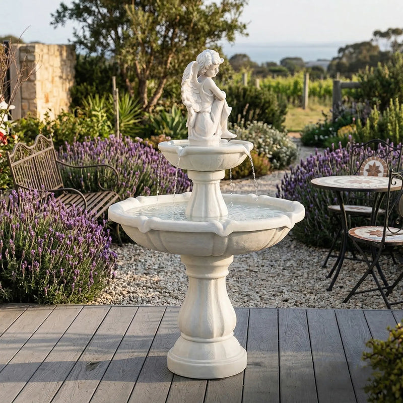 OUTWAY angel solar garden fountain on a timber deck overlooking a lavender garden and vineyard with wrought iron garden furniture and stone wall in an Australian coastal setting