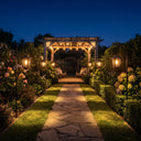 Multiple HeritageHook lanterns lining stone pathway to pergola at night, showcasing their use as ambient pathway lighting that enhances garden symmetry and guides guests with warm, consistent glow.