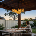 Woman sitting at a table in a backyard with decorative outdoor lighting, text overlay about product features.Outway PT0912 solar rattan 6-head pendant light hanging from timber pergola warm glow through woven shades alfresco dining table dusk