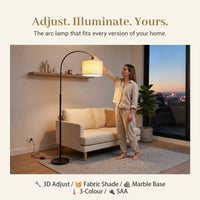 Woman adjusting an arc lamp in a living room with text 'Adjust. Illuminate. Yours.'