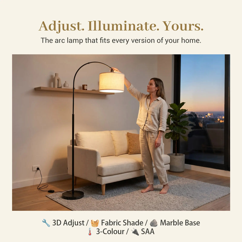 Woman adjusting an arc lamp in a living room with text 'Adjust. Illuminate. Yours.'