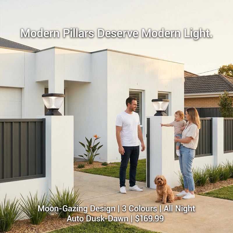 Young family with baby and golden dog standing at entrance of modern white rendered home in daytime, two Nexi Solar Pillar Lights PT0112 on white fence pillars, text overlay: Modern Pillars Deserve Modern Light. Moon-Gazing Design, 3 Colours, All Night, Auto Dusk-Dawn, $169.99