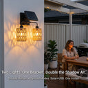 Solar wall lights on a wall with outdoor setting and woman sitting at a table.