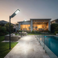OUTWAY Nexa T007 solar pole lights installed along a backyard patio and swimming pool area, enhancing outdoor safety and ambiance.