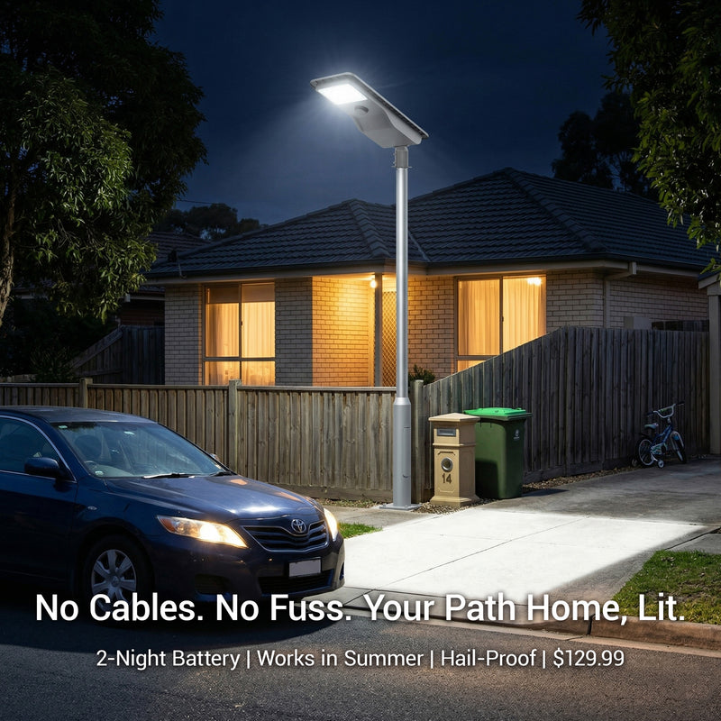 Street light illuminating a driveway at night with a house in the background.