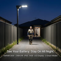 Person walking on a path illuminated by a street light with text about battery life and features.