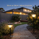Garden pathway with adjustable height solar lights and a dog lying on the grass.