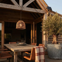 PT0913 solar rattan pendant lamp providing warm ambient lighting above an outdoor dining table