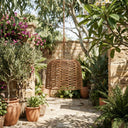 PT0907 Solar Woven Pendant Light hanging in a sunlit Mediterranean-style garden courtyard, surrounded by olive trees, bougainvillea, and terracotta pots. Highlights its handwoven PE rattan texture and seamless integration into natural, rustic landscapes.
