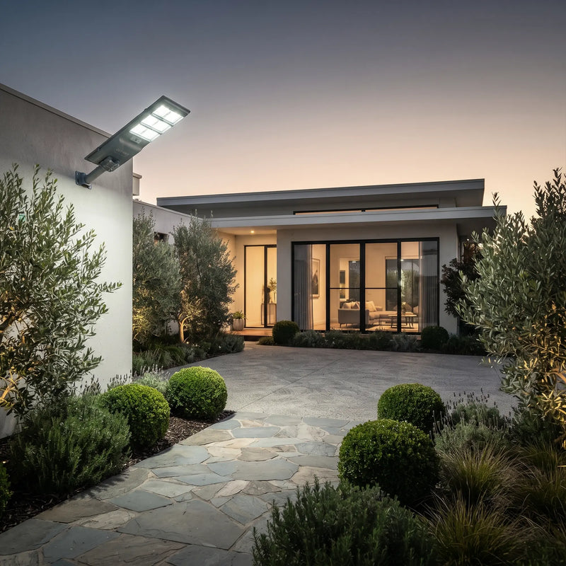 Nexa StreetGlow Pro T007 solar street light illuminating a modern home driveway and garden pathway at dusk.
