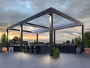 Modern outdoor patio pergola with a dark metal frame, retractable roof panels, integrated lighting, and an attached bar counter with dining chairs, shown on a rooftop at dusk.