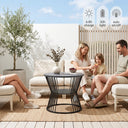 Family sitting on outdoor furniture set with a table, enjoying a sunny day.
