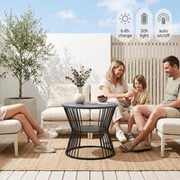 Family sitting on outdoor furniture set with a table, enjoying a sunny day.