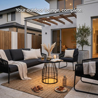 Outdoor lounge area with black furniture, table, and decor in a modern patio setting.