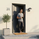 Man with coffee standing at front door number 31 with Serra solar wall light installed beside entrance, text: Looks Like a Sparky Did It. Charges in 3 Hours.