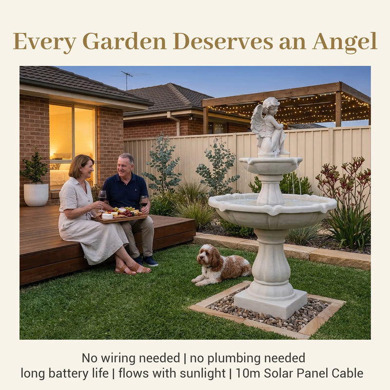 OUTWAY angel solar garden fountain in an Australian backyard at dusk with a couple sharing a cheese board and wine on a deck beside a cavoodle dog with fairy lights overhead and text overlay Every Garden Deserves an Angel No wiring needed no plumbing needed long battery life flows with sunlight 10m Solar Panel Cable