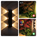 Outdoor wall light fixture with lighting effects on a stone wall and garden scene.
