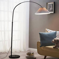 Floor lamp in a living room with a sofa and decorative pillows.