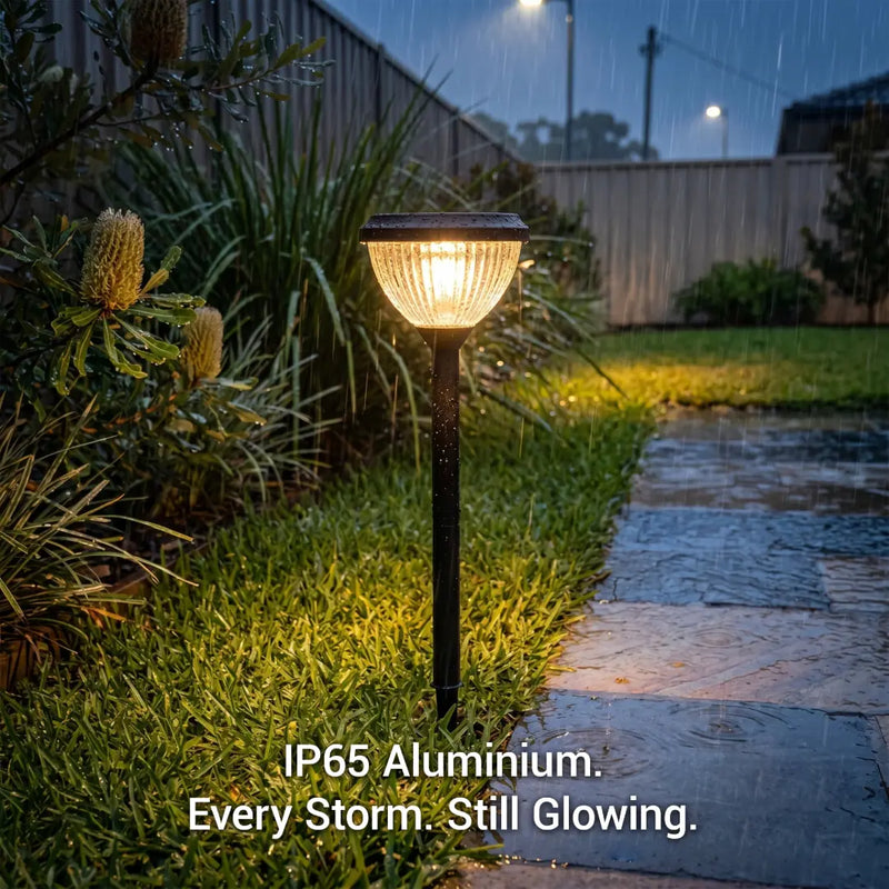 Garden light fixture on a grassy area with text 'IP65 Aluminium. Every Storm. Still Glowing.'