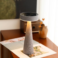 Modern table lamp with a marble-like base on a wooden surface