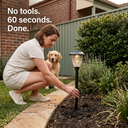 Woman installing solar light into garden bed in 60 seconds without tools, with text “No tools. 60 seconds. Done.” and golden retriever watching — emphasizing user-friendly setup for DIY homeowners.