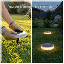 DIY installation of solar ground lights, showing a hand inserting the light into the grass and the illuminated result, text "No electrician needed".