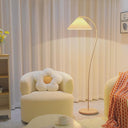 Modern living room with a yellow armchair, floor lamp, and decorative pillows.
