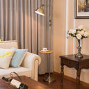 Living room with beige sofa, floor lamp, and side table with flowers