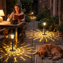 Solar lights illuminating stone path beside outdoor reading nook with cat and sleeping dog, casting intricate shadow art on ground — ideal for cozy, pet-inclusive evening relaxation zones.