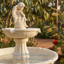 Angel fountain in cream yellow finish against eucalyptus backdrop, with text “Made of resin, fiberglass, and sandstone material” — reinforcing durability, weather resistance, and premium tactile feel for long-term outdoor use.