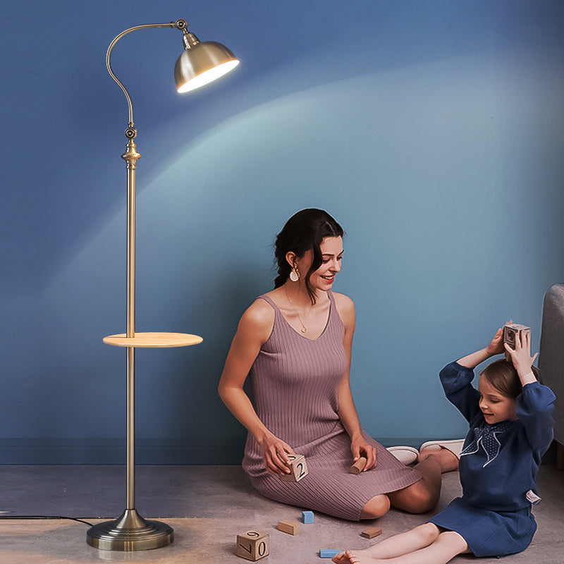 Woman and child playing with toys near a floor lamp against a blue wall.