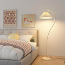 Modern bedroom with a bed, floor lamp, and wall art