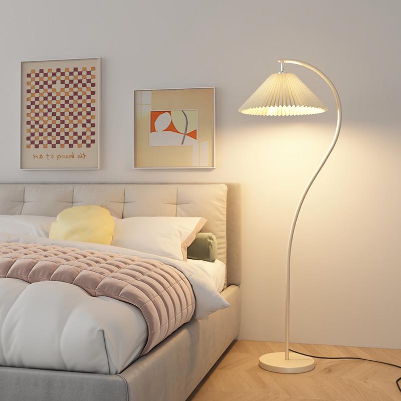 Modern bedroom with a bed, floor lamp, and wall art