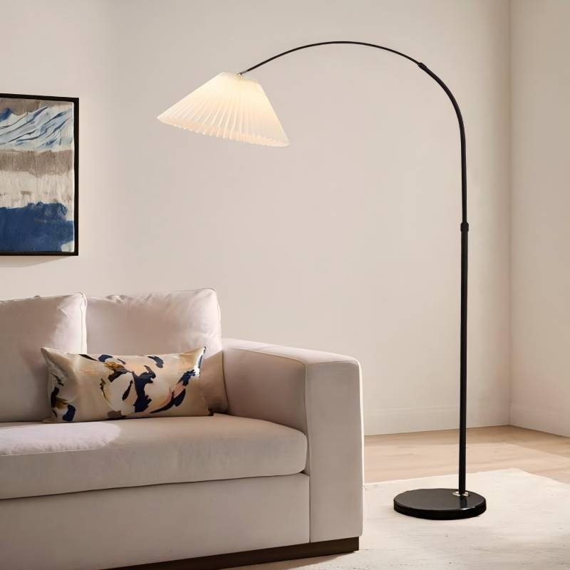 Floor lamp next to a white sofa with a decorative pillow in a living room setting.