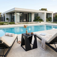 Modern outdoor setting with pool, lounge chairs, and a small table.