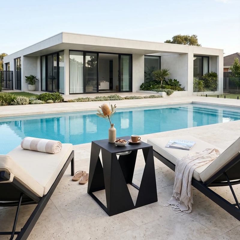Modern outdoor setting with pool, lounge chairs, and a small table.